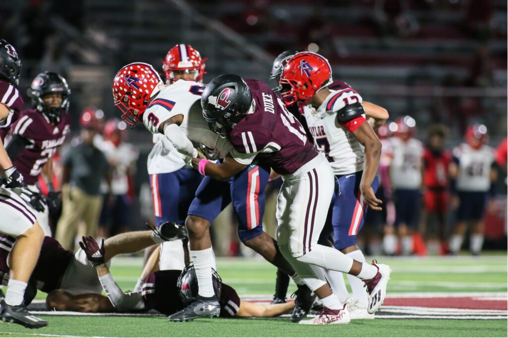 DEFENSIVE STOP - Pearland senior linebacker Andre Duke (19) sticks Alief Taylor wide receiver Bricen Brantley for a short gain. The Oilers held the Lions to minus -14 yards rushing for the game. Pearland beat Taylor 27-16 to even their season record to 4-4 and 3-2 in district to keep in the playoff hunt. Pearland will travel to face Strake Jesuit on Friday, October 28 at 7:00 p.m. at Crusader Stadium. (Photo by Lloyd Hendricks)